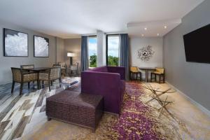 奥兰多东奥兰多UCF区希尔顿逸林酒店的客厅配有紫色沙发和桌子