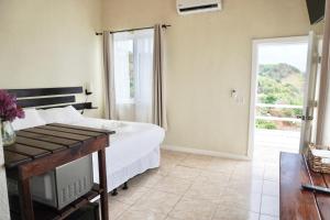 罗阿坦Ocean View Hotel and Restaurant的一间卧室设有一张床和一个滑动玻璃门
