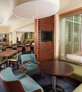 奥兰多奥兰多机场希尔顿花园酒店的一间带桌椅和电视的用餐室