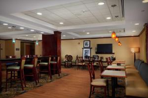 纽波特纽斯Hampton Inn Newport News-Yorktown的餐厅设有酒吧和桌椅