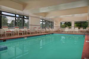纽波特纽斯Hampton Inn Newport News-Yorktown的一个带桌椅和窗户的大型游泳池