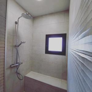 马拉加B&B Sara Sueño的带淋浴的浴室以及墙上的电视。