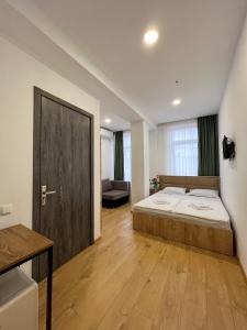 泰拉维Hotel mia Telavi的一间卧室设有一张大床,铺有木地板