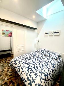 马赛Le Cabanon du Vallon des Auffes的一间卧室配有一张带黑白色棉被的床