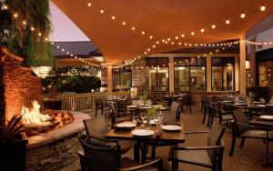 凤凰城北凤凰城欢乐谷希尔顿花园酒店的一间带桌椅和火坑的餐厅