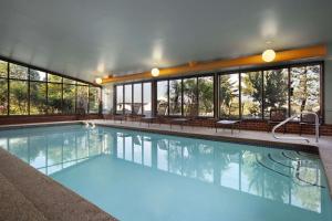 波特兰缅因州波特兰希尔顿合博套房酒店的一座大型游泳池,位于一座带窗户的建筑内