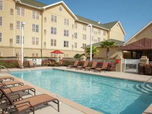 彭萨科拉Homewood Suites by Hilton Pensacola Airport-Cordova Mall Area的酒店游泳池设有椅子,酒店