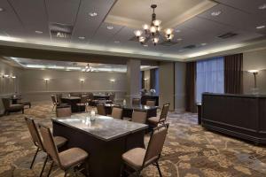 波特兰缅因州波特兰希尔顿合博套房酒店的一间会议室,配有桌椅和吊灯