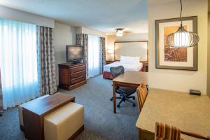 彭萨科拉Homewood Suites by Hilton Pensacola Airport-Cordova Mall Area的酒店客房设有一间带一张床和一张书桌的卧室