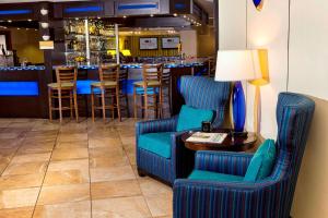 南波特兰波特兰希尔顿逸林酒店的酒吧配有蓝色的椅子和一张带台灯的桌子
