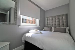 格拉斯哥2 Bedroom Apartment at SECC Hydro FREE PARKING的卧室配有一张带镜子的白色大床