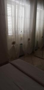 阿莱齐奥幻影住宿加早餐旅馆的一间设有白色窗帘和窗户的客房