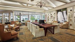 达拉姆三角研究园罗利达勒姆机场希尔顿逸林酒店的大堂设有桌椅和桌子,还有一间客房。