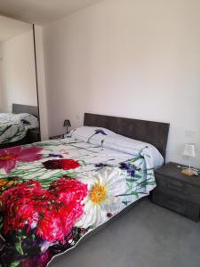 奥里斯塔诺CARPE DIEM的一间卧室配有一张带花卉棉被的床