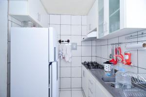 贝洛奥里藏特Exotic Home Brazil的白色的厨房配有水槽和冰箱