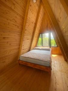 奥尔塔贾Aşı garden bungalow evleri的木制客房的一张床位,设有窗户