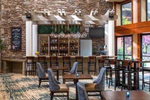 罗内特公园索诺马酒乡希尔顿逸林酒店的一间带桌椅的餐厅和一间酒吧