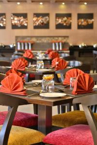 艾哈迈达巴德HOTEL G EXPRESS Formerly Known as TGB Express的用餐室配有桌椅和红色餐巾
