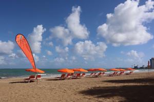 圣胡安圣胡安希尔顿合博套房酒店 - 酒店及赌场的海滩上一排橙色的遮阳伞和椅子