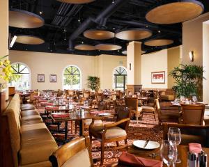 安纳海姆阿纳海姆希尔顿双树套房度假酒店&会议中心的一间在房间内配有桌椅的餐厅