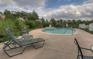 派恩赫斯特奥姆斯特德村希尔顿惠庭套房酒店的一个带椅子的庭院和一个带喷泉的游泳池