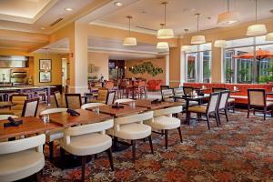 伯克利圣路易斯机场希尔顿花园酒店的用餐室配有木桌和椅子
