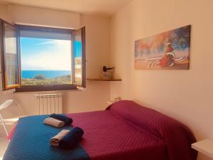 阿尔盖罗Voce Del Mare - sea view- Alghero Airport的一间卧室设有一张床和一个大窗户