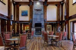 特拉基Hampton Inn & Suites Tahoe-Truckee的一间带桌椅和壁炉的用餐室