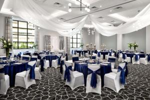 坦帕西岸坦帕机场希尔顿合博套房酒店的一间拥有蓝白色装饰的宴会厅,配有桌椅