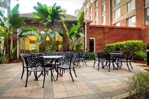 坦帕Hilton Garden Inn Tampa East Brandon的一组桌子和椅子,位于大楼前
