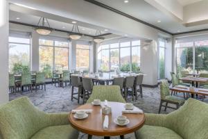 塔尔萨南塔尔萨希尔顿花园酒店的用餐室设有桌椅和窗户。