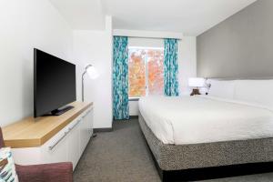 塔尔萨南塔尔萨希尔顿花园酒店的一间卧室配有一张床和一台平面电视