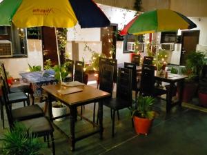 阿格拉Hotel Sidhartha Walking Distance From TajMahal的一间带桌椅和遮阳伞的餐厅