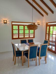 佩雷拉Habitación tranquila en casa campestre的一间配备有白色桌子和蓝色椅子的用餐室