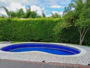 佩雷拉Habitación tranquila en casa campestre的 ⁇ 形前方的蓝色瓷砖游泳池