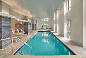 华盛顿Embassy Suites by Hilton Washington DC Convention Center的一座带椅子的游泳池和一座游泳池