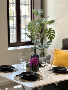 科尔多瓦Lofts Jumaral - La Magdalena的桌子,上面有盘子,玻璃杯,花瓶