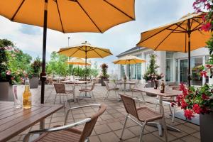 多瓦尔蒙特利尔机场希尔顿花园酒店的一个带桌椅和遮阳伞的庭院