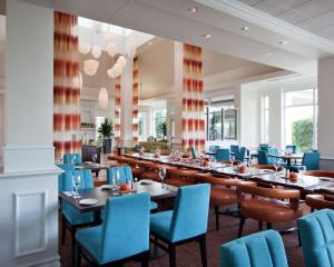 多瓦尔蒙特利尔机场希尔顿花园酒店的一间配备有桌子和蓝色椅子的用餐室