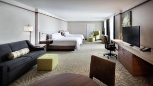 多瓦尔蒙特利尔机场希尔顿花园酒店的酒店客房配有床、沙发和电视。