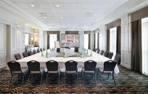 多瓦尔蒙特利尔机场希尔顿花园酒店的大型会议室,配有长桌子和椅子