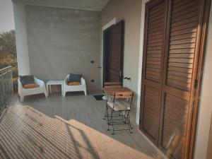 桑吉内托B&B Il Castello的阳台配有两把椅子和一张桌子,还有一个门