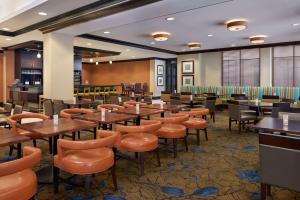 米西索加多伦多西机场/密西沙加希尔顿花园酒店的用餐室配有木桌和椅子