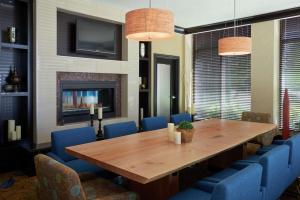 米西索加多伦多西机场/密西沙加希尔顿花园酒店的一间带木桌和蓝色椅子的用餐室