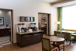 劳埃德明斯特劳埃德明斯特希尔顿汉普顿酒店的客厅配有桌子和咖啡站