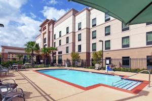 休斯顿德克萨斯休斯顿北IAH汉普顿套房酒店的一座大建筑前的游泳池