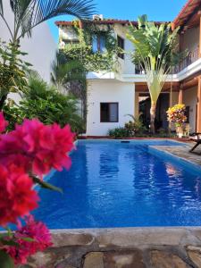 格拉纳达Hotel con Corazón的一座鲜花盛开的房子前的游泳池