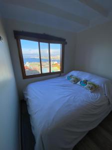 瓦尔帕莱索Oasis en Cerro Alegre的卧室配有白色的床和窗户