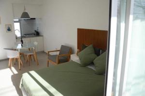 拉普拉塔Casa14的一间卧室配有一张床铺和一张桌子,还设有一间厨房