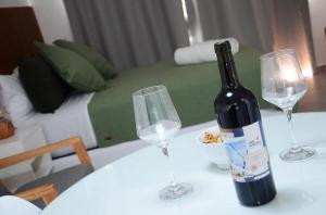 拉普拉塔Casa14的一张桌子上摆放着一瓶葡萄酒和两杯酒杯